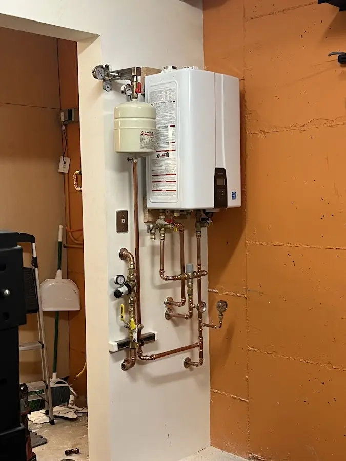 Plumbing technician inspecting water heater connections in Orange Cove